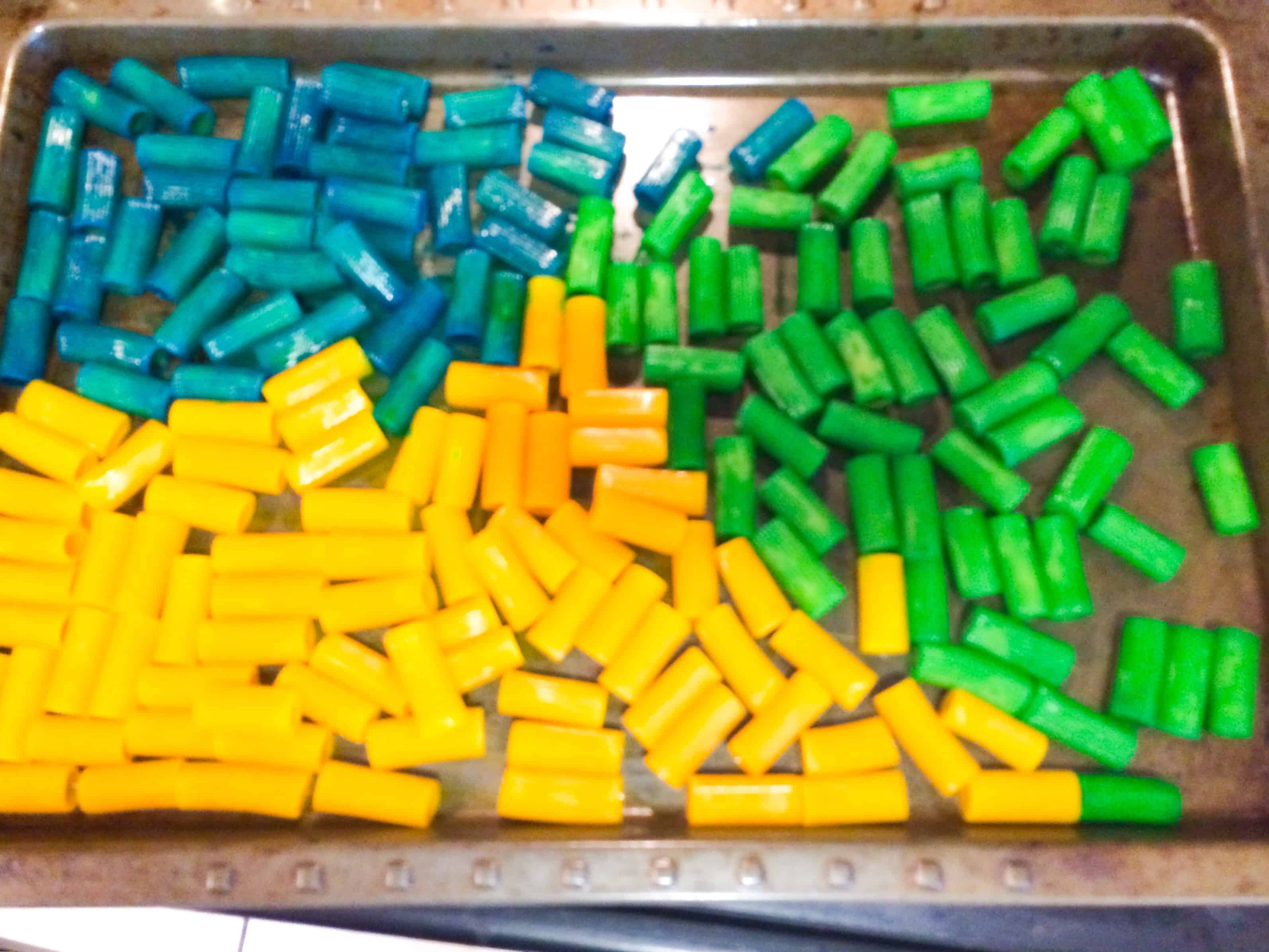 This school sensory bin uses colored pasta as a base and a wooden bus, school and people toys for kids to play with. A great way to prep for back to school. #sensoryplay #parenting #kidsactivities #sensory #spd #preschool #backtoschool