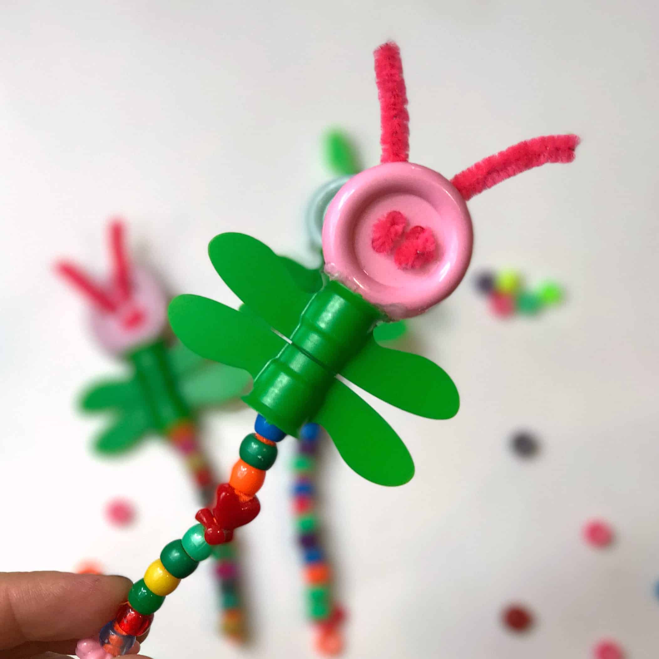 Use applesauce pouch caps to create this cute dragonfly kids craft! A fun upcycled fine motor activities for kids of many ages.