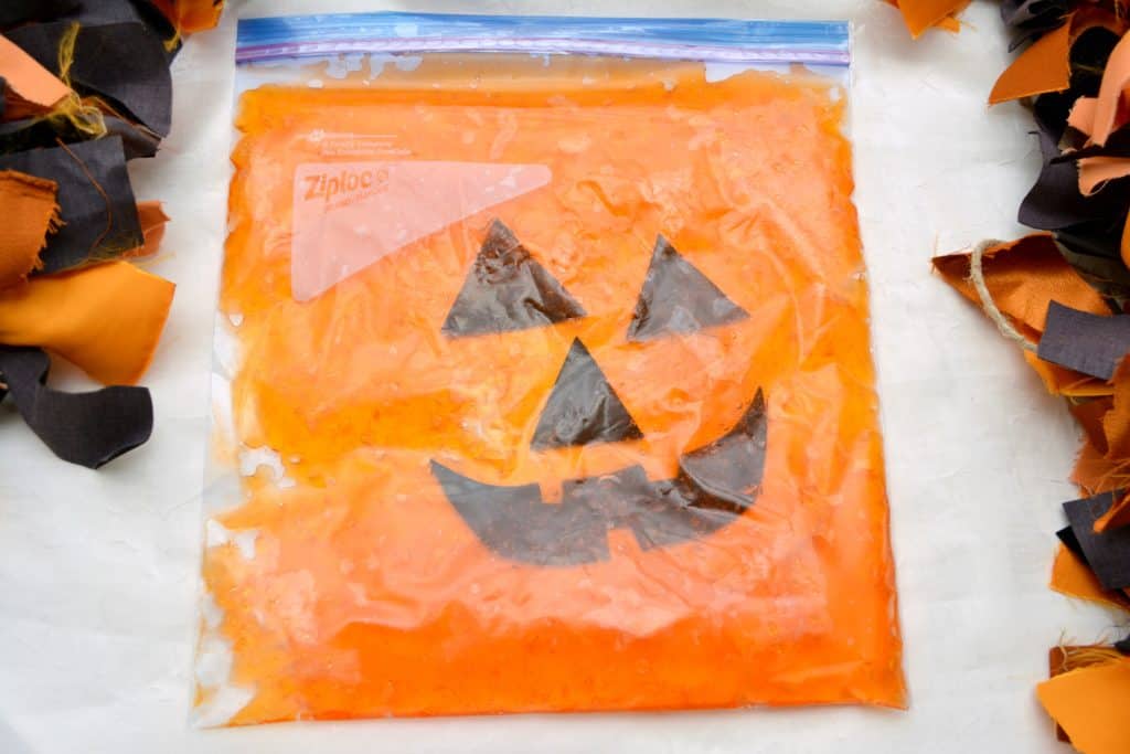 This jack-o-lantern sensory bag for babies is the perfect way to engage young kids in sensory play for Halloween and the Fall.