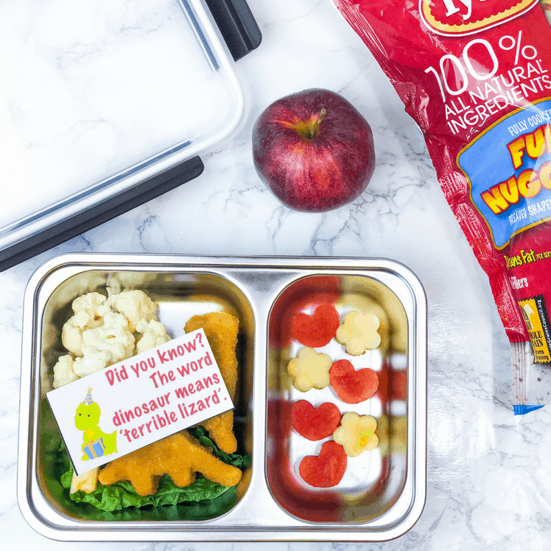 This dinosaur lunch uses dinosaur shaped chicken nuggets and fun fruit and veggies to create a dinosaur themed bento box lunch for school! Also included are free dinosaur lunchbox notes to print. #backtoschool #lunchforkids #bentobox #kidslunch #dinosaur #parenting