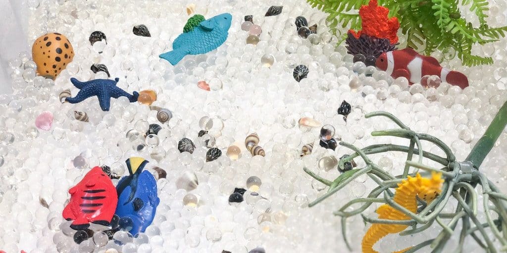 sensory bin with water beads, seahorse and fish 