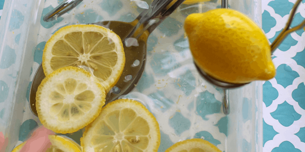 sliced lemons being ladled by a slotted spoon 